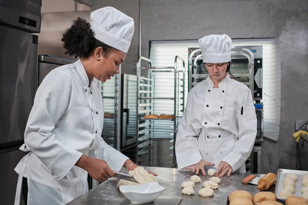 Dos Cocineras Profesionales Uniformes Blancos Delantales Amasan Masa Pastelería Huevos —  Fotos de Stock