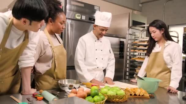 Kochkurs Seniorchef Kochuniform Bringt Jungen Kochkursteilnehmern Bei Teig Kneten Und — Stockvideo