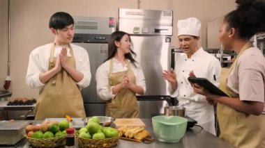 Hobi mutfak kursu, aşçı üniforması giyen kıdemli aşçı genç aşçılık sınıfı öğrencilerine elma soymayı ve doğramayı öğretiyor. Hamur işleri için malzemeler, paslanmaz çelik mutfakta meyveli turtalar..