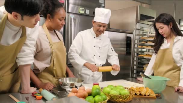 Kochkurs Seniorchef Kochuniform Bringt Jungen Kochkursteilnehmern Bei Teig Kneten Und — Stockvideo