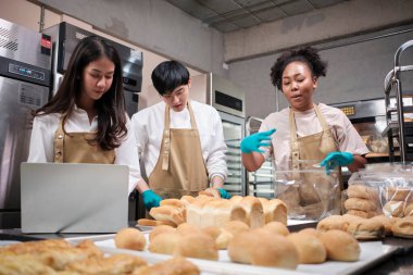 Üç genç arkadaş ve ekmek hamuru ve hamur işleriyle meşgul olan başlangıç partnerleri çevrimiçi yemek yaparken, paketlerken ve pastane, küçük işletme girişimcileri,.
