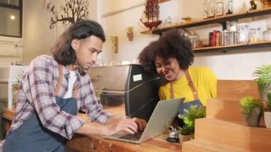 İki kafe işletme ortağı ve arkadaşları, Afro-Amerikan kadın ve Taylandlı erkek barmenler kahve dükkanının tezgahında birlikte neşeli bir gülümseme, mutlu servis işi ve KME girişimcisi.