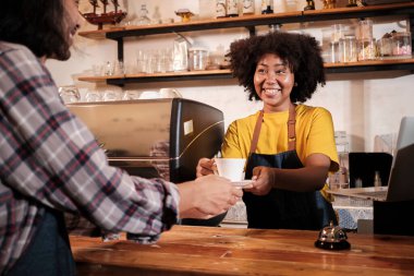 İki kafe işletme ortağı ve arkadaşları, Afro-Amerikan kadın ve Taylandlı erkek barmenler kahve dükkanının tezgahında birlikte gülüyorlar, mutlu servis işleri ve KME girişimcisi..