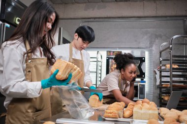 Üç genç arkadaş ve ekmek hamuru ve hamur işleriyle meşgul olan başlangıç partnerleri çevrimiçi yemek yaparken, paketlerken ve pastane, küçük işletme girişimcileri,.