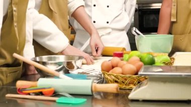 Aşçı üniformalı, önlüklü aşçı üniformalı, yemek sınıfı öğrencileri hamur işlerine malzeme dolduran, pastane yemekleri için bastıran, paslanmaz çelik mutfakta meyveli turtalar hazırlayan şefin yakın çekimi..