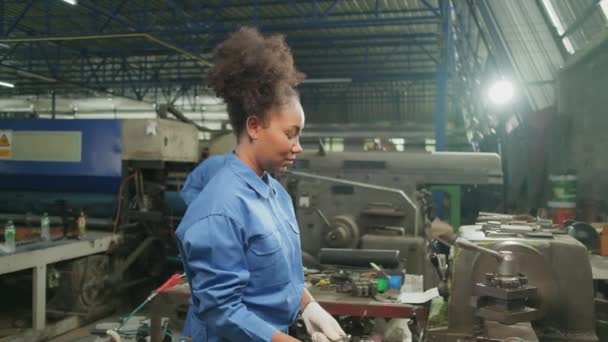 金属加工精密工具 機械旋盤機械 鉄鋼製造工場のスペアパーツワークショップでは 1人のプロの若い女性工業エンジニアの労働者が安全制服で働いています — ストック動画