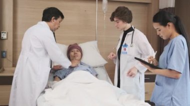 Üniformalı profesyonel doktorlar Asyalı erkek hastayı steteskopla kontrol ediyor, hastane koğuşundaki yatağında ilaç tedavisi görüyor, tıbbi klinik, kanser muayenesi....