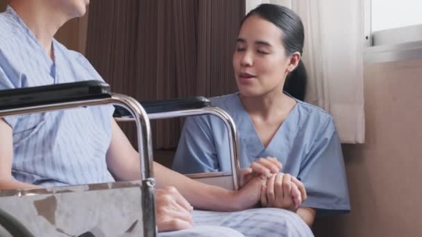 Uniformed Young Asian Female Therapy Doctor Holding Hands Wheelchair Male — Vídeo de stock