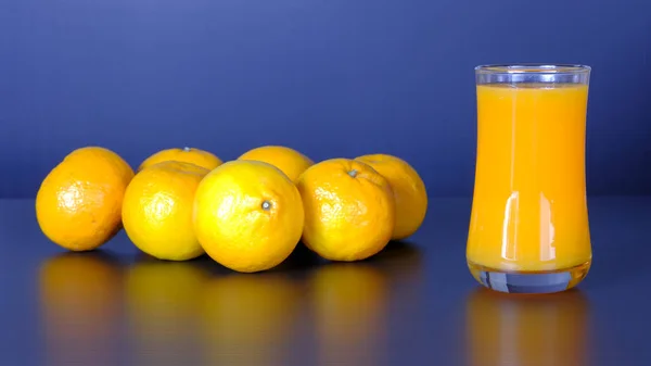 特写和生动的工作室镜头 一杯橙汁 一组黑色背景的天然新鲜橙子 有机饮料 美味的健康点心和美味的维生素营养饮料 — 图库照片