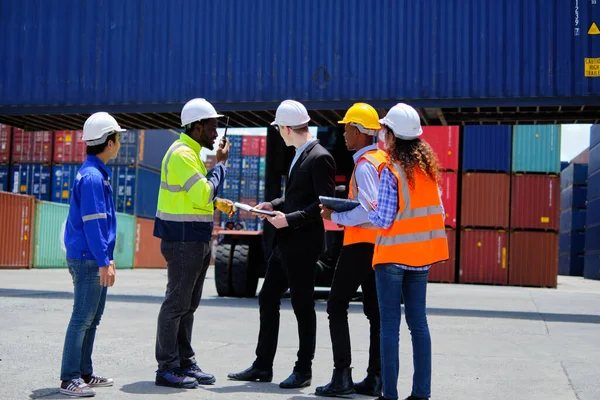 身穿安全制服和头戴安全帽的多种族工人团体 与成堆的集装箱 装卸控制和管理航运货物 货物运输行业一起在物流终端码头工作 — 图库照片