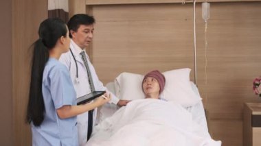 Üniformalı profesyonel doktorlar Asyalı erkek hastayı steteskopla kontrol ediyor, hastane koğuşundaki yatağında ilaç tedavisi görüyor, tıbbi klinik, kanser muayenesi....