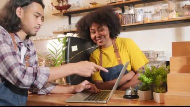 İki kafe işletme ortağı ve arkadaşları, Afro-Amerikan kadın ve Taylandlı erkek barmenler kahve dükkanının tezgahında birlikte neşeli bir gülümseme, mutlu servis işi ve KME girişimcisi.