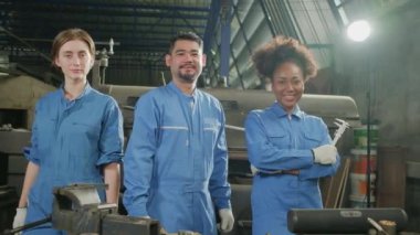 Güvenlik üniforması giyen çok ırklı endüstri çalışanları birlik, kollarını kavuşturma ve makine fabrikasında gülümseme ve neşeyle birlikte mutlu çalışmalarını ifade etme, profesyonel mühendis mesleği.