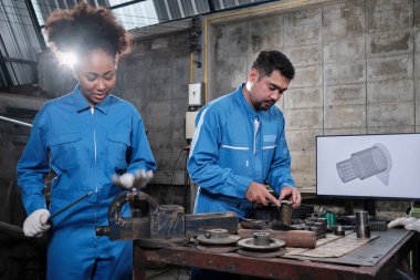İki profesyonel endüstri mühendisi, güvenlik üniformaları, metal işçiliği, bir monitörde mekanik çizim, torna makinesi aletleri ve imalat fabrikasında üretim bölümü atölyesinde ortak.. 