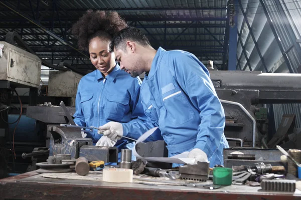 Two professional industry workers teams in safety uniforms and engineers\' partners worked with metalwork tools, checked mechanical precision for lathe machines, and workshops in manufacturing factory.