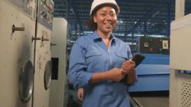 Profesyonel kadın Afro-Amerikan ve Beyaz Mühendisler ortağı işten sonra başlıklarını çıkarıp kameraya mutlu bir gülümseme ve endüstriyel imalat fabrikasında pozitif ifadelerle bakıyorlar.. 