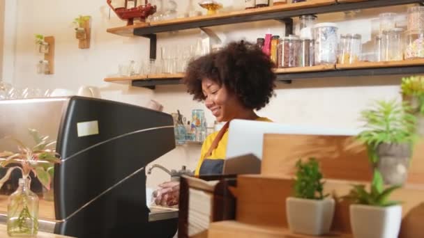 アフリカ系アメリカ人女性のカフェバリスタは ノートパソコンでオンライン顧客の注文に満足し コーヒーショップのカウンターバーで笑顔で明るい作品 小さなビジネススタートアップ起業家ライフスタイル — ストック動画