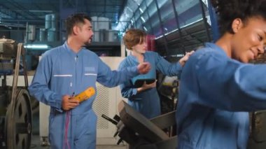 mec 068Multiracial professional industry engineer teams in safety uniforms work by inspecting machines' voltage current, checking, and maintaining at manufacture factory, electric system service occupations.
