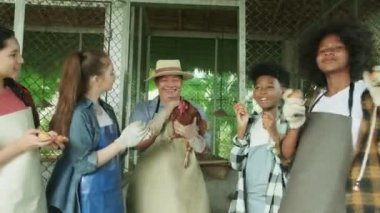 Multiracial children collect chicken eggs and play uncle farmer's hen in agriculture and livestock education at organic farm, kids group joyful and smile, happy outdoor learn in natural countryside.