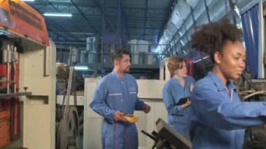 Güvenlik üniformalı çok ırklı profesyonel mühendislik ekipleri, makinelerin voltaj akımlarını kontrol ederek, kontrol ederek ve fabrikada, elektrik sistemi işlerinde çalışırlar..