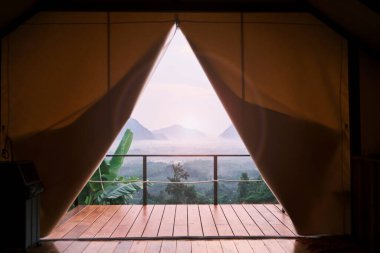 Stunning scenery view of tropical landscape looking from camping tent in foggy morning, beautiful Asia journey, natural unseen environment from the resort balcony, tranquil resting travel destination.