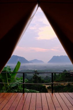 Stunning scenery view of tropical landscape looking from camping tent in foggy morning, beautiful Asia journey, natural unseen environment from the resort balcony, tranquil resting travel destination.