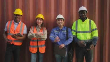 Portrait of a group of multiracial workers team, Black and Asian in safety uniforms, arms crossed, smile and looking at camera on metal sheet background, logistic containers transportation industry. 