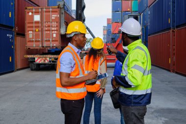 African American male workers and teams in safety uniforms and hardhats use walkie-talkies, work at logistic crane with stacks of containers, load control shipping goods, and cargo transport industry.