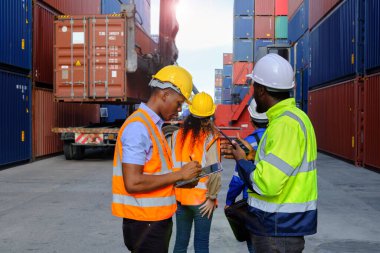 African American male workers and teams in safety uniforms and hardhats use walkie-talkies, work at logistic crane with stacks of containers, load control shipping goods, and cargo transport industry.