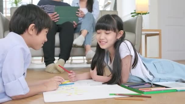 Asian Thai Siblings Lying Living Room Floor Drawing Homework Colored — Vídeo de stock