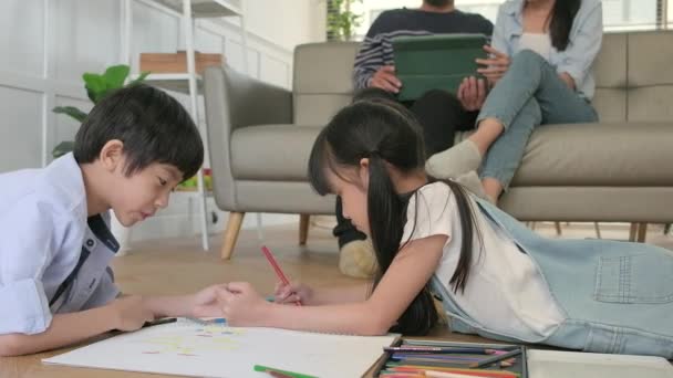 Asian Thai Siblings Lying Living Room Floor Drawing Homework Colored — Stock Video