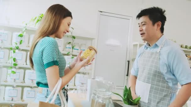 Asian Male Shopkeeper Describes Natural Organic Products Woman Customer Refill — Vídeo de stock