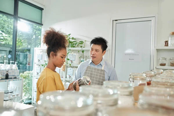 Asian Male Shopkeeper Describes Natural Organic Products Woman Customer Refill — Stockfoto