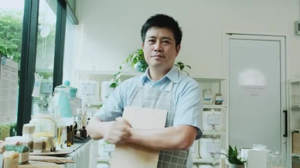 アジアの男性店主の肖像は笑顔とカメラを見て 腕は補充店で交差し 天然物 廃棄物ゼロ食料品 プラスチックフリー 環境に優しい 持続可能なライフスタイル — ストック動画