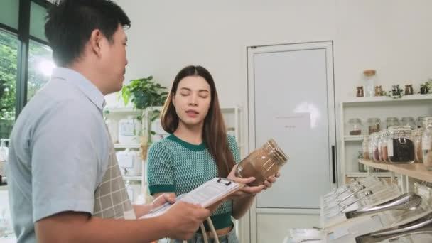 Asian Male Shopkeeper Describes Natural Organic Products Woman Customer Refill — Video Stock