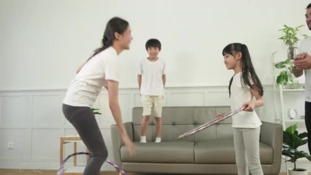 健康的亚洲泰国人家庭 父母和孩子们在一起玩呼啦圈 在白色客厅进行健身训练和健康锻炼 过家庭生活和参加周末活动都很开心 — 图库视频影像