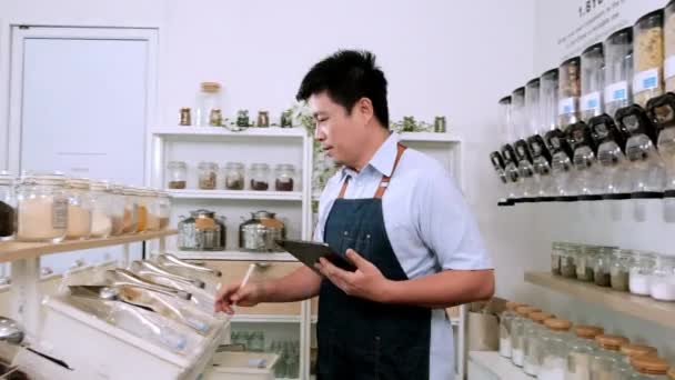 Asian Male Shopkeeper Checks Stock Organic Products Ingredients Shelves Refill — Stock Video