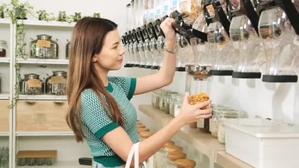 一位白种人女性顾客将谷物食品装入玻璃瓶中 将可重复使用的容器 零废物 无塑料食品 可持续的生活方式作为杠杆 — 图库视频影像