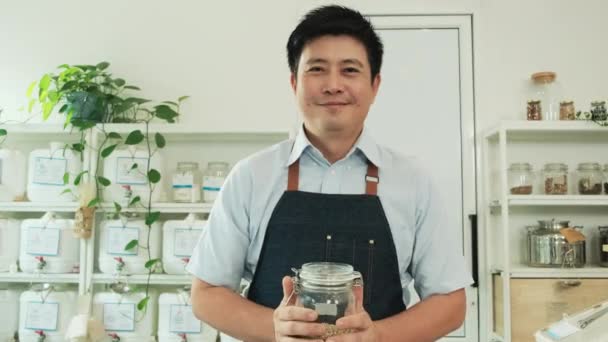 Retrato Hombre Tailandés Comerciante Sonríe Mira Cámara Con Frasco Vidrio — Vídeos de Stock