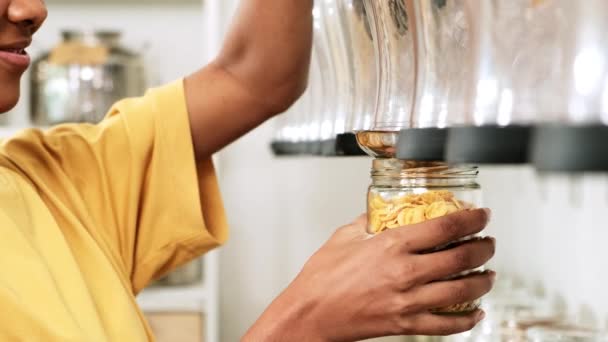 非裔美国女性顾客将谷物食品装在玻璃瓶中 将可重复使用的容器放在再装箱中 零废物和无塑料食品 环境友好 可持续的生活方式 — 图库视频影像