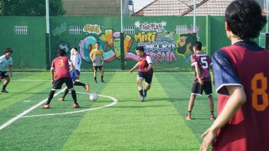 Depok, Endonezya - 11 Ekim 2021: Futbol oynayan genç futbolcular grubu. Futbol takımları arasındaki futbol maçı