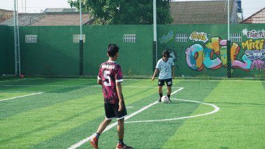 Depok, Endonezya - 11 Ekim 2021: Futbol oynayan genç futbolcular grubu. Futbol takımları arasındaki futbol maçı