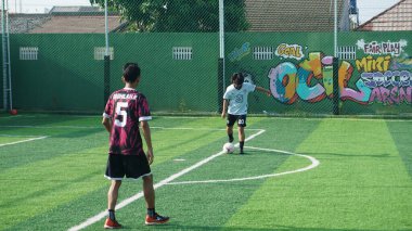 Depok, Endonezya - 11 Ekim 2021: Futbol oynayan genç futbolcular grubu. Futbol takımları arasındaki futbol maçı