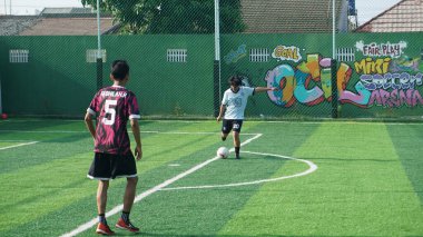 Depok, Endonezya - 11 Ekim 2021: Futbol oynayan genç futbolcular grubu. Futbol takımları arasındaki futbol maçı