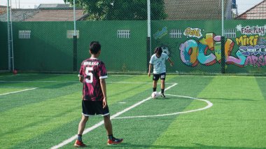 Depok, Endonezya - 11 Ekim 2021: Futbol oynayan genç futbolcular grubu. Futbol takımları arasındaki futbol maçı