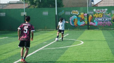 Depok, Endonezya - 11 Ekim 2021: Futbol oynayan genç futbolcular grubu. Futbol takımları arasındaki futbol maçı