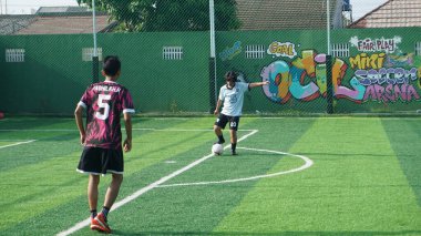 Depok, Endonezya - 11 Ekim 2021: Futbol oynayan genç futbolcular grubu. Futbol takımları arasındaki futbol maçı