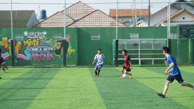 Depok, Endonezya - 11 Ekim 2021: Futbol oynayan genç futbolcular grubu. Futbol takımları arasındaki futbol maçı