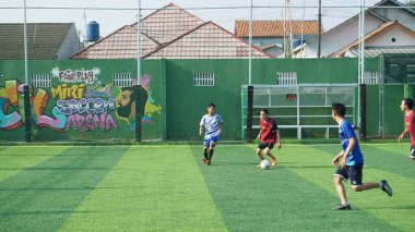 Depok, Endonezya - 11 Ekim 2021: Futbol oynayan genç futbolcular grubu. Futbol takımları arasındaki futbol maçı