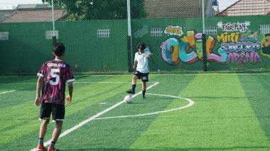 Depok, Endonezya - 11 Ekim 2021: Futbol oynayan genç futbolcular grubu. Futbol takımları arasındaki futbol maçı